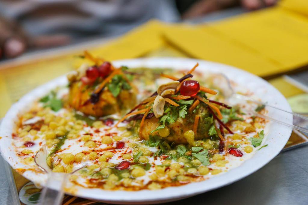 Chaat Papri · Crisp fried dough wafers along with boiled chickpeas, boiled potatoes, yogurt and tamarind chutney and topped with chaat masala and sev.
