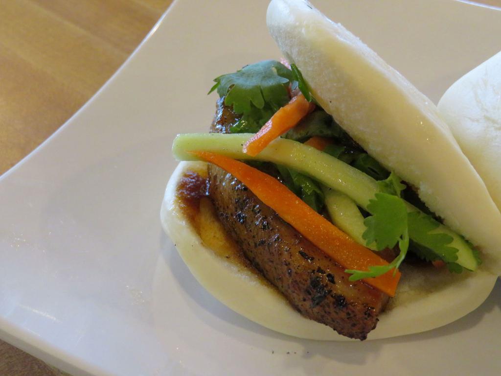 Bao Buns (2 pc) · In a sweet rice bun, house spicy hoisin, pickled carrots, cilantro, cucumber, green onion.