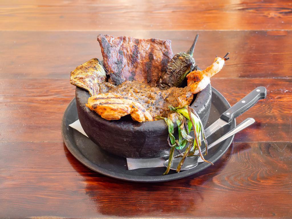 Molcajete Tradicional · Grilled carne arrachera, chicken breast, spicy shrimp, fire-roasted onion, Chile burrito and grilled nopales (cactus leaf) in our spicy molcajete salsa with beans, rice and tortillas on the side.