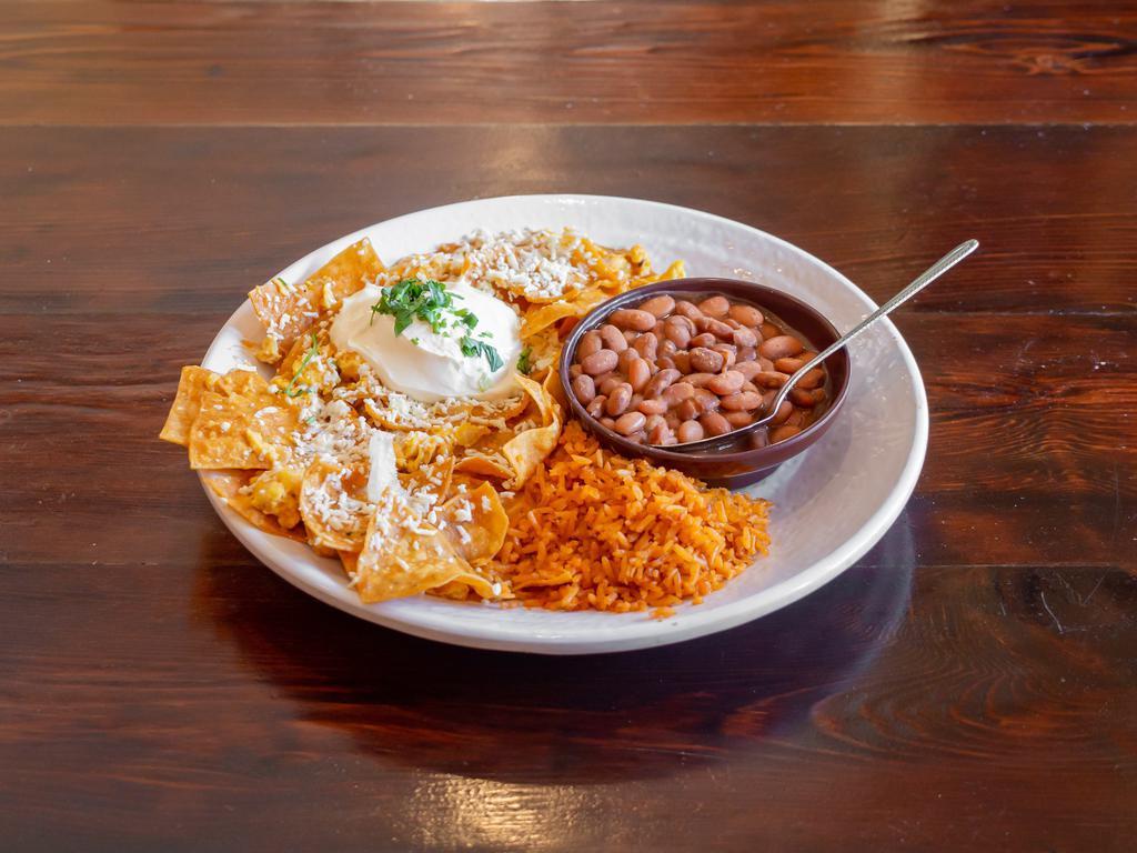 Chilaquiles Breakfast · Crispy corn tortilla chips and scrambled eggs in guajillo and ranchera salsas, with Mexican crema, queso cotija and cilantro. Served with beans and rice.