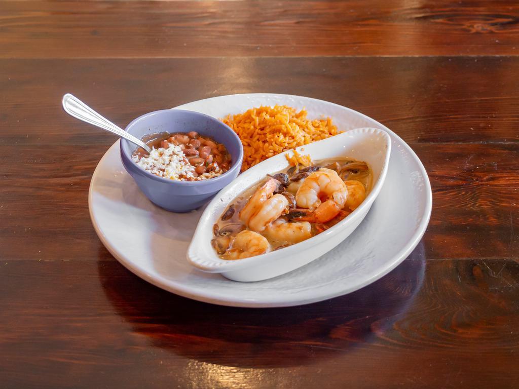 Mojo De Ajo Shrimp · Prawns and mushrooms sauteed in a roasted-garlic butter and white wine sauce. Served with beans, rice and tortillas.