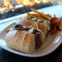 Philly Cheesesteak · Shaved rib-eye steak, your choice of cheese, peppers, onions & mushrooms on a toasted roll.