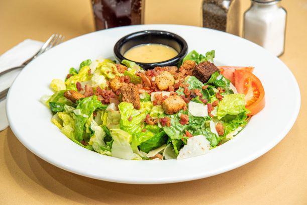 Caesar's Empire Salad · Crisp romaine, tossed in our Caesar dressing with croutons, tomato, shredded Parmesan cheese and bacon bits. 