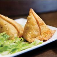 Vegetable Samosa · Deep fried snack-crisp, triangular wheat casing filled with spiced peas, potatoes and a spri...