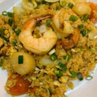 42. Pineapple Fried Rice · Pineapple fried rice with egg, onion, tomato, peas, carrots, cashew nut, raisins and curry p...