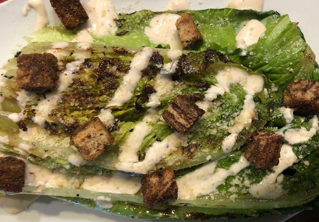 Grilled Caesar Salad · Wedge of Grilled Romaine, Parmesan, Croutons, Lemon, Caesar Dressing (Dressing contains anchovies).