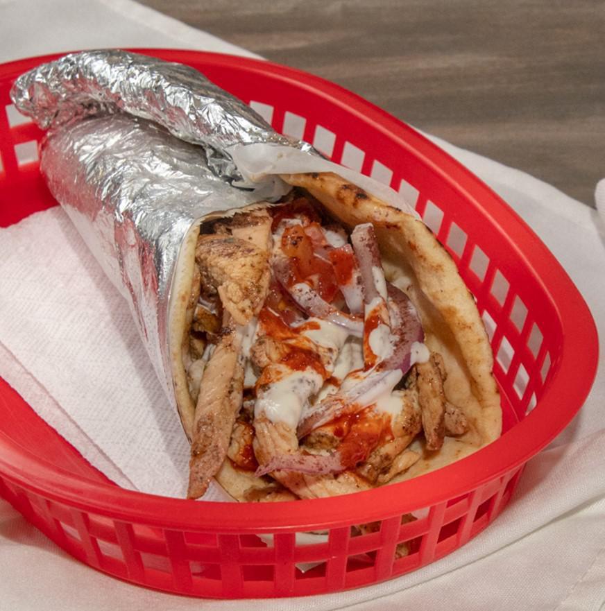 Chicken Shawarma Wrap · Marinated chicken breast, thin sliced wrapped in pita bread with tomato, onions, and our white sauce and hot sauce.