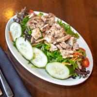 Jerk Chicken Salad · Chopped boneless jerk chicken on a bed of spring mix, carrots, cucumbers and tomatoes.