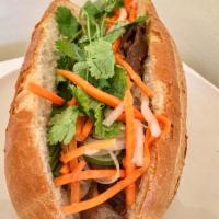 Grilled Sesame Beef Sandwich (Bánh mì bò lụi) · Served with mayo, pate, cucumber, daikon and carrot pickles, cilantro, house special dressin...