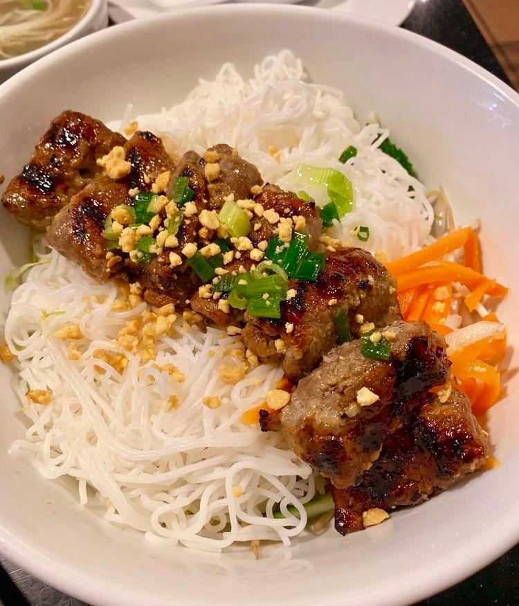 Grilled Sesame Beef brochette over Rice Vermicelli (Bún bò lụi) · Served with shredded lettuce, cucumber, pickles daikon and carrot, scallion oil garnish, crushed roasted peanuts and fish sauce on the side.