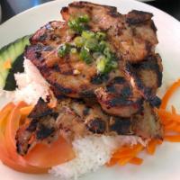 Grilled Pork Chop over White Rice (Cơm sườn nướng) · Served with daikon & carrot pickles, tomato, cucumber, scallion oil garnish, fish sauce (on ...
