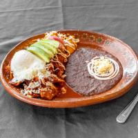 Chilaquiles con pollo · Fried tortilla with red sauce topped with one fried egg and chicken, red onions, crema, ques...
