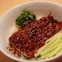 Unagi Donburi · BBQ eel with eel sauce arranges over a bowl of sushi rice, green onion, and sesame seeds.