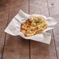 Garlic Naan · Soft bread, flavored with fresh garlic, freshly baked in a clay oven. Vegetarian.