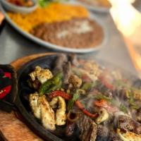 Fajitas · Fajitas are prepared with steak, chicken, or shrimp, bell peppers, and onions served on a si...