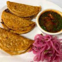 Tacos de Birria · Served in corn or flour tortilla, stuffed with birra chopped onion and cilantro on top.