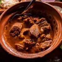 Birra en Caldo · Marinated beef stew wind in its own soup with chopped onions and lime on the side.