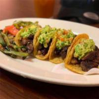 Tacos de Arrachera Estilo Tijuana · Spread refried beans on soft corn or flour tortilla filled with grilled skirt steak topped w...