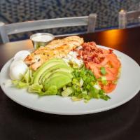 Chicken Cobb Salad  · Greens garnished with juicy grilled chicken, egg, crispy bacon, tomatoes, onions, green onio...