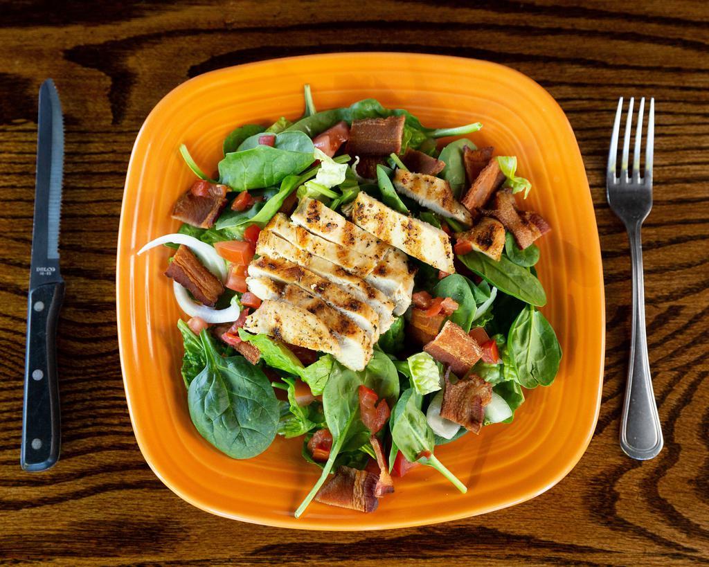 Spinach Chicken Salad · Fresh spinach and crisp romaine lettuce, tossed with tomatoes, onions and bacon. Topped with grilled chicken and served with your choice of dressing.