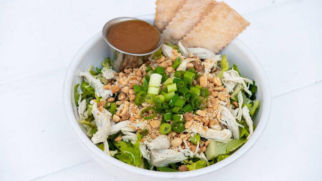 Asian Chicken Salad · Sliced romaine, savoy cabbage with mint, cilantro, scallions, roast chicken, sesame seeds, and ground peanuts, served with a peanut dressing.
