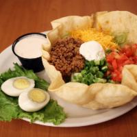 Taco Salad · A crisp tortilla shell filled with shredded lettuce, diced tomatoes, shredded cheese, green ...