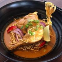Kao Soy Gai · Chicken legs with egg noodle in special yellow curry soup topped with red and green onions.