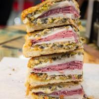 Whole Muffaletta · Sesame round toasted bun with ham salami mortadella provolone and our house made olive dress...