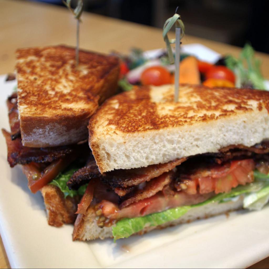 b.l.t. (＆ maybe a.) · hill’s pepper bacon, organic tomato, acadian greens, smoked onion aioli, on toasted house-made potato bread, served with your choice of side. add avocado and make it a BLAT. 
