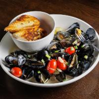 Pan Steamed Mussels · White wine, roasted garlic, citrus butter and grilled bread.