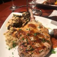 Grilled Pork Tenderloin Chop with Dijon Gravy · Served over smashed red potatoes with artichokes, Parmesan, crispy brussels sprouts and chip...