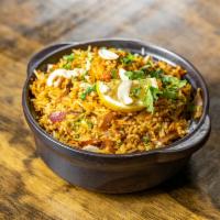 Chicken Biryani · Indian basmati rice flavored with saffron, cooked mughlai style with boneless chicken, nuts,...