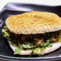 207. Chinese Stewed Pork Burger · Served with scallions and cilantro on a sesame bun.