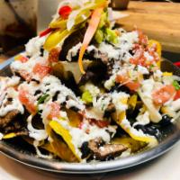 Loaded Nachos · Corn chips, topped with vegan refried beans, fresh mozzarella, Muenster cheese, pickled jala...