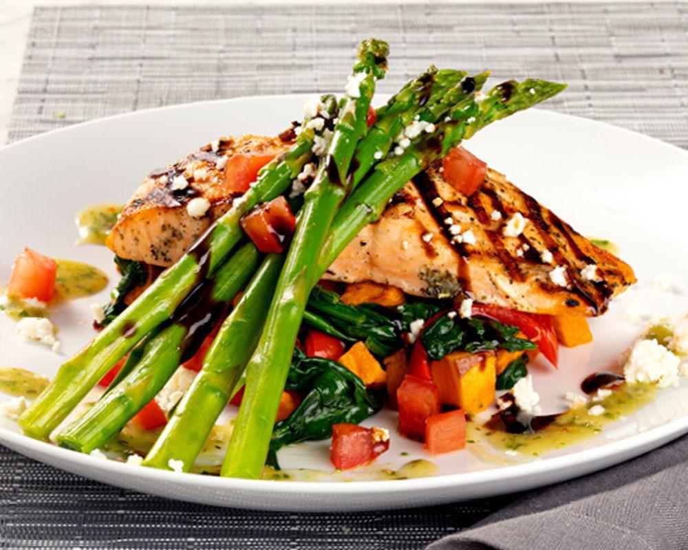 Grilled Salmon Fresca* · Grilled salmon, asparagus, sweet potatoes, spinach, red peppers, feta, Roma tomatoes, pesto vinaigrette, balsamic glaze

