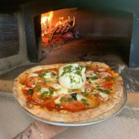Delilah Pizza · Margherita pie with a ball of burrata in the middle drizzled with pesto.