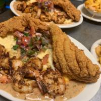 New Orleans Catfish Shrimp and Grits · Fried catfish served atop cheese grits topped in our seafood cream with New Orleans styled s...