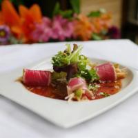 Tuna on the Beach · Spicy crab meat and avocado wrapped with sliced seared tuna, served with housemade onion dre...