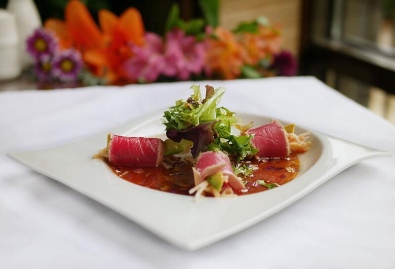 Tuna on the Beach · Spicy crab meat and avocado wrapped with sliced seared tuna, served with housemade onion dressing.