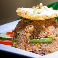Kampong Fried Rice · Eggs, onions, chili, sambal anchovies, peas, carrots, shrimp paste and garnish with tomato a...