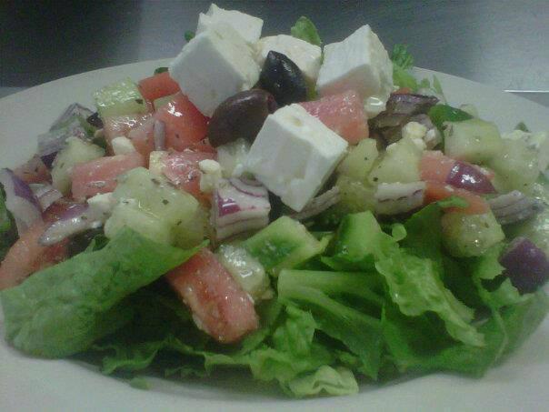 Greek Salad · Tomato, cucumbers, green peppers and onions tossed in vinaigrette, topped with feta cheese and black olives.