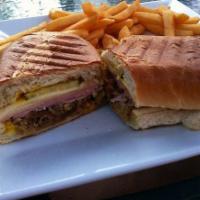 Cubano Sandwich · Slow roasted Cuban pork, ham, pickle, Swiss cheese and yellow mustard served hot on Cuban br...