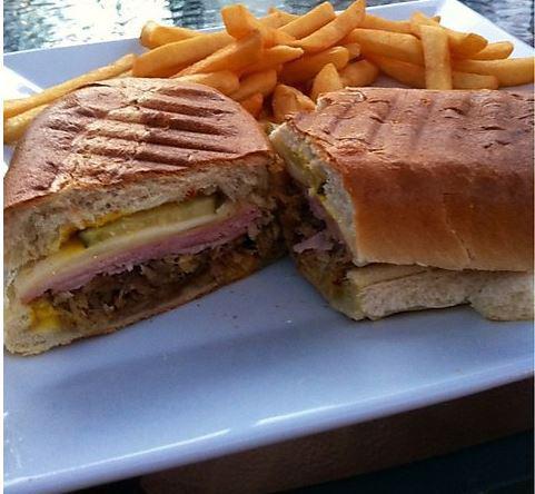 Cubano Sandwich · Slow roasted Cuban pork, ham, pickle, Swiss cheese and yellow mustard served hot on Cuban bread.