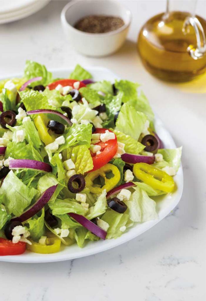 Greek Salad Family Size · Fresh-cut lettuce blend, feta cheese crumbles, black olives, sliced tomatoes, red onions and banana peppers; served with Greek dressing.