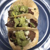 Tacos Arrachera · Grilled skirt steak, cilantro, onion and molcajete sauce.