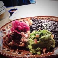 Carnitas Michoacanas · Slow cooked pork shoulder, avocado, cilantro and tortillas and morita sauce.