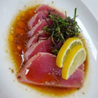 Tuna Tataki  · Seared tuna with red onion and greens with spicy chili house dressing.