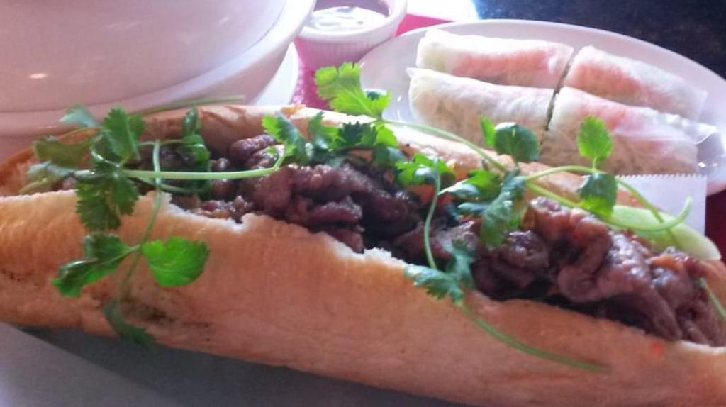 BBQ Pork Baguette · Our BBQ pork banh mi comes with our special butter, daikon (pickled carrots and radishes), cucumbers, jalapenos and topped off with cilantro.