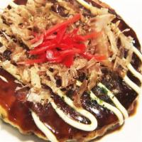 Okonomiyaki · Japanese savory vegetable pancake, topped with bonito flakes and seaweed flakes. Mayo and sp...