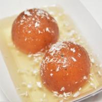 77. Gulab Jamun · 2 pieces. Deep fried farmer's cheese balls in honey and rose water syrup topped with almond.